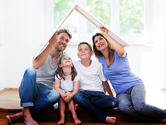 Photo of family holding cardboard made to look like a roof over their heads