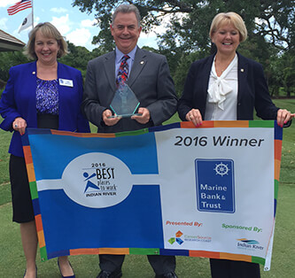 Photo of Marine Employees holding 2016 Best Places to Work Indian River Banner