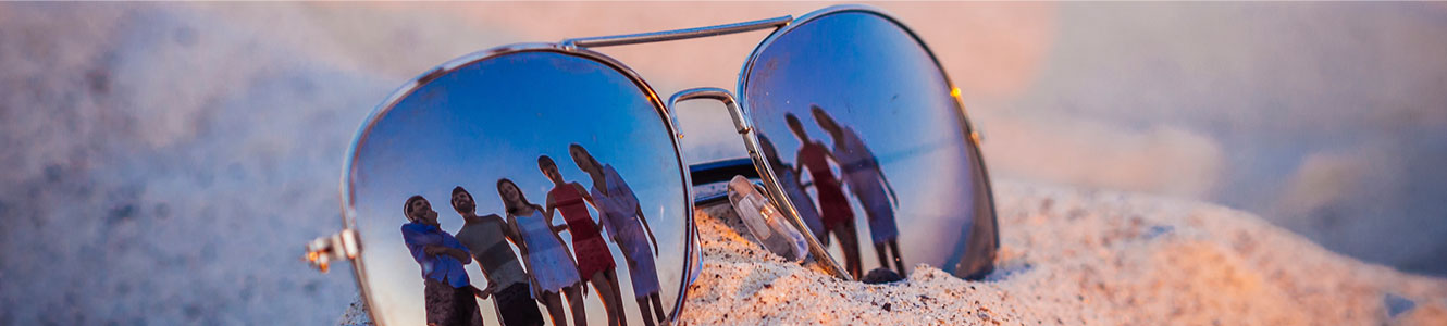 Community Header - photo of sunglasses in the sand with people reflected in the lenses
