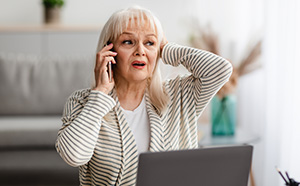 Older woman with a surprised look, talking on the phone