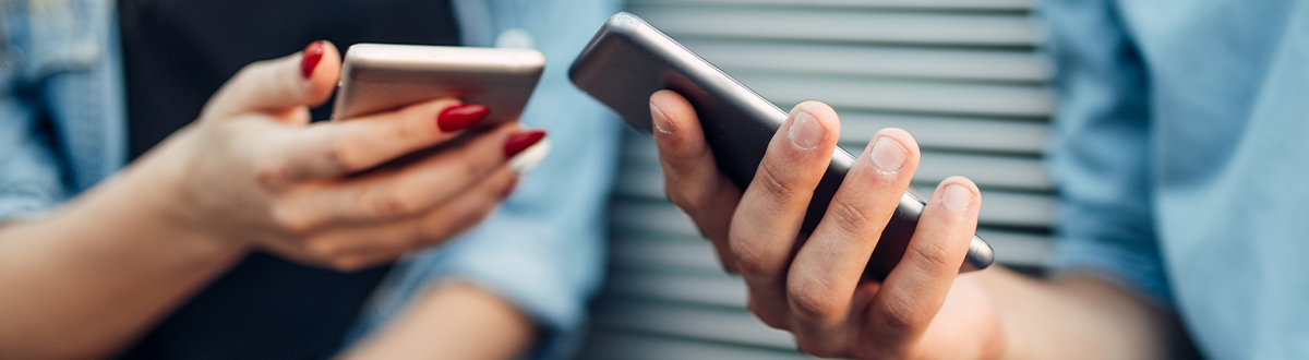 Two women holding cell phones